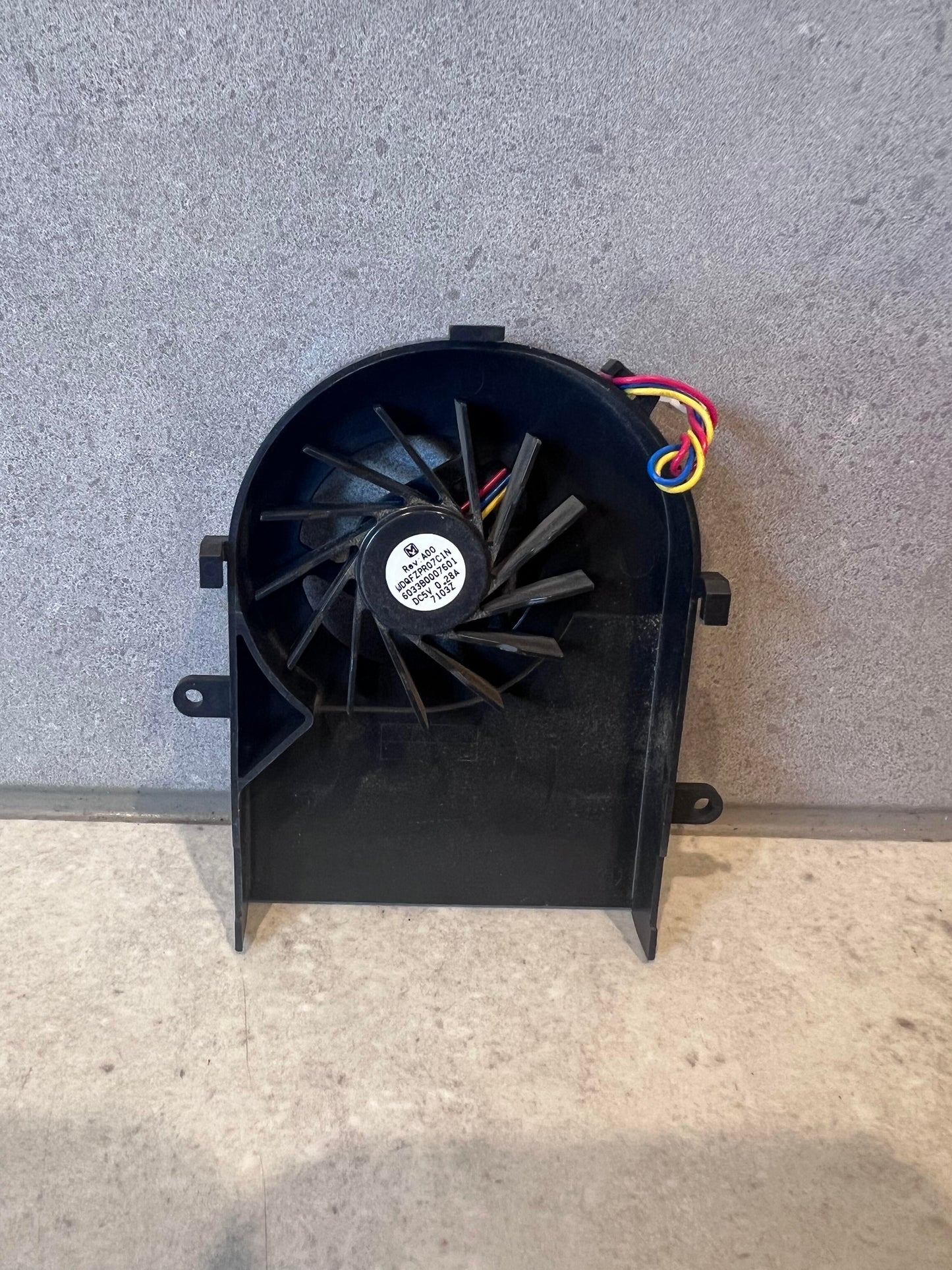 Front view of replacement laptop cooling fan module with multicolored wiring