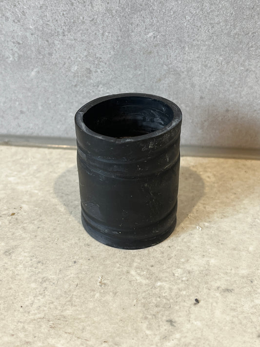 Black rubber pipe connector coupling on a stone surface