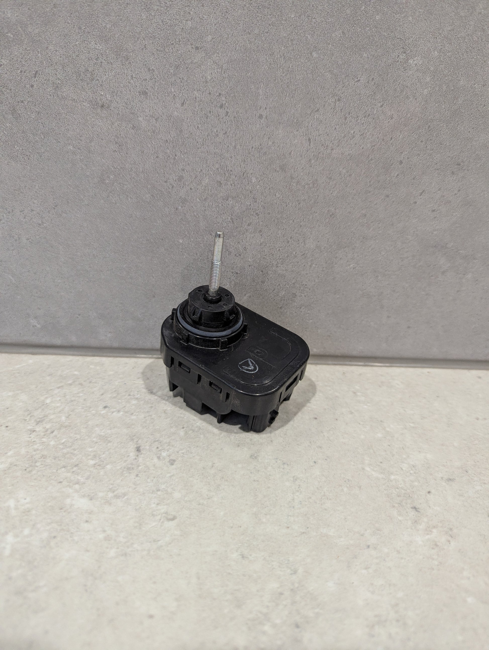 Nissan headlight leveling motor on a light surface