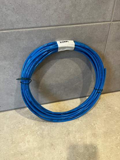 Coiled blue pneumatic tubing hose on tiled floor