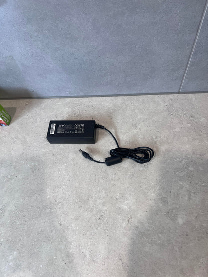 ISO 60W AC adapter with power cord on a light surface