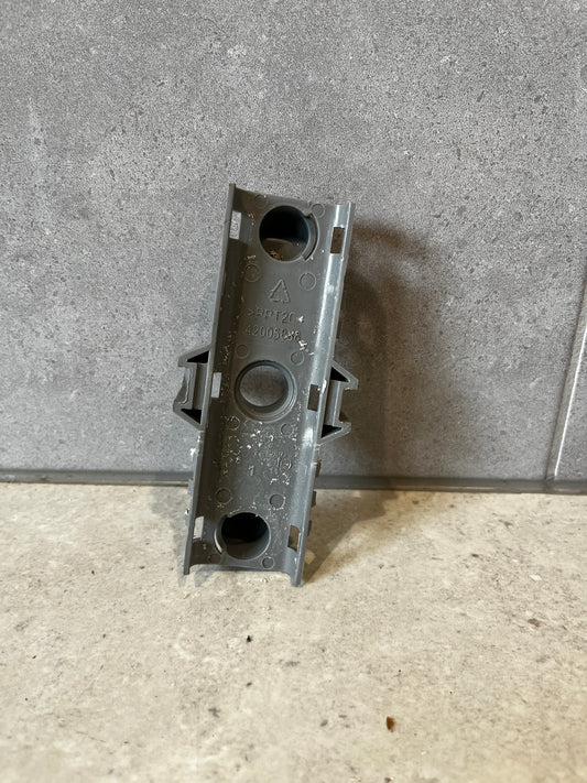 Gray plastic mounting bracket shown against gray tile background