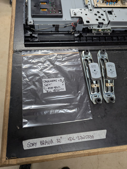 Pair of Sony Bravia KDL-32W5500 TV speakers with metal frames and product label, shown next to TV internal parts