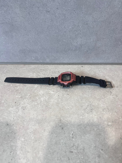 Sports digital quartz watch with black strap displayed flat on light surface