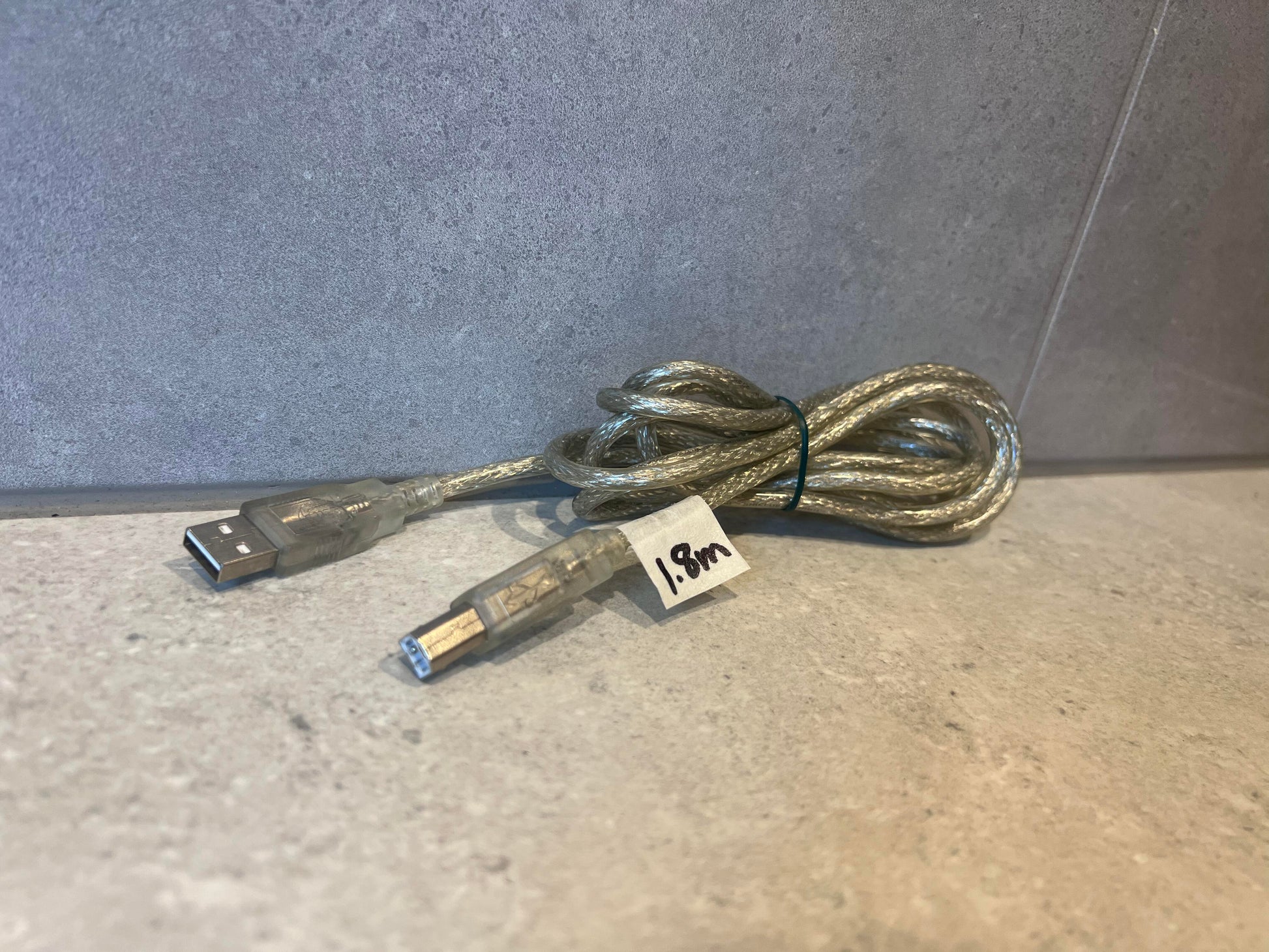 USB A to USB B cable with transparent shielding, 1.8m length, coiled on a neutral background