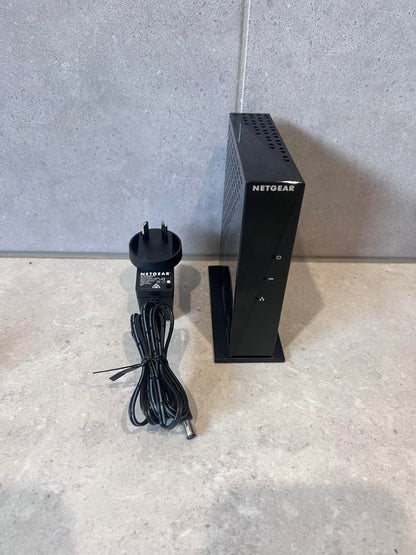 NETGEAR DM200 VDSL modem with power adapter and cable on countertop