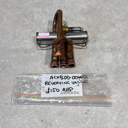Dunlab 4-way reversing valve with copper fittings on a gray surface, labeled with model ACXB00-0040.