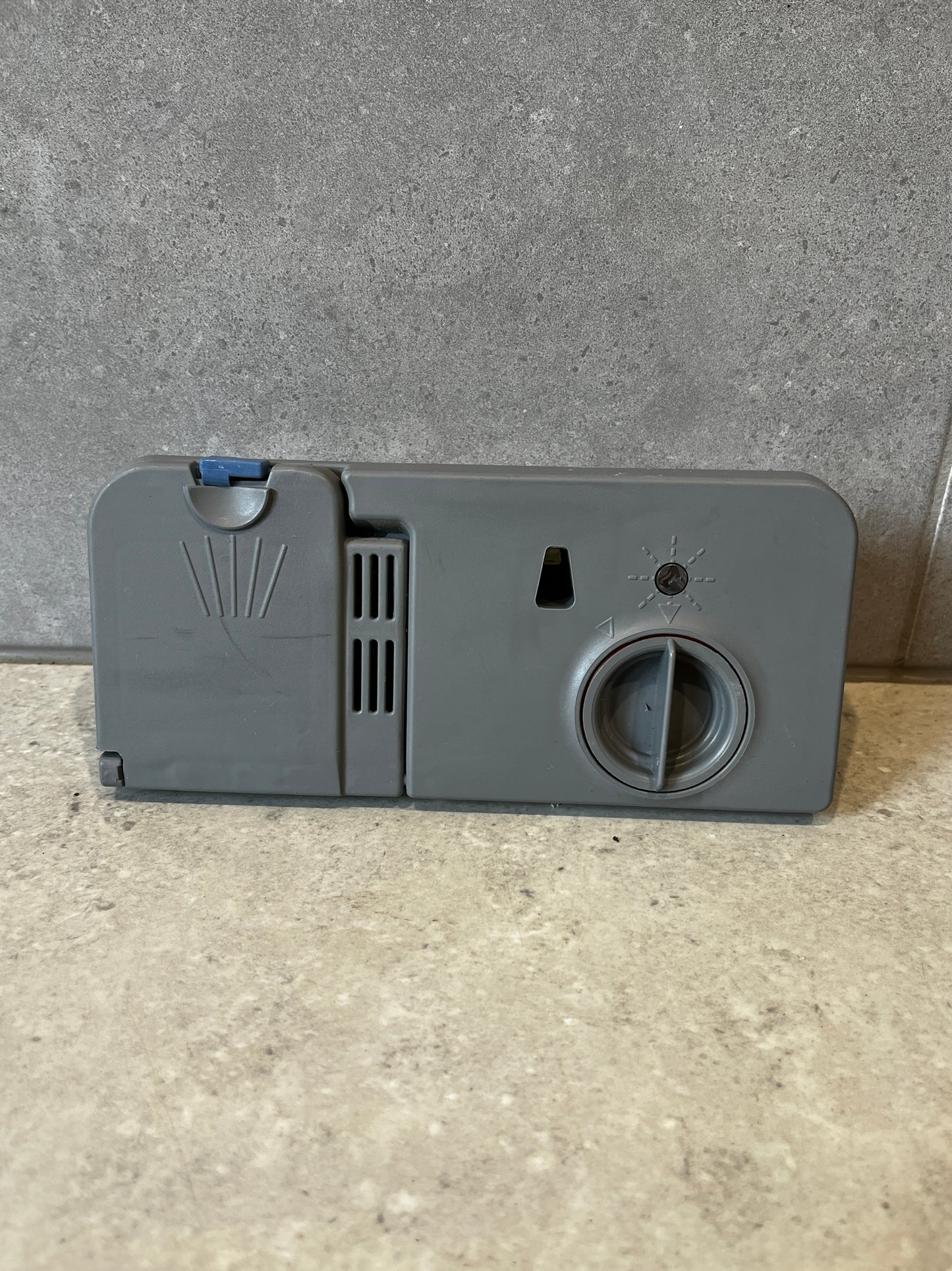 Front view of dishwasher detergent dispenser assembly with control dial