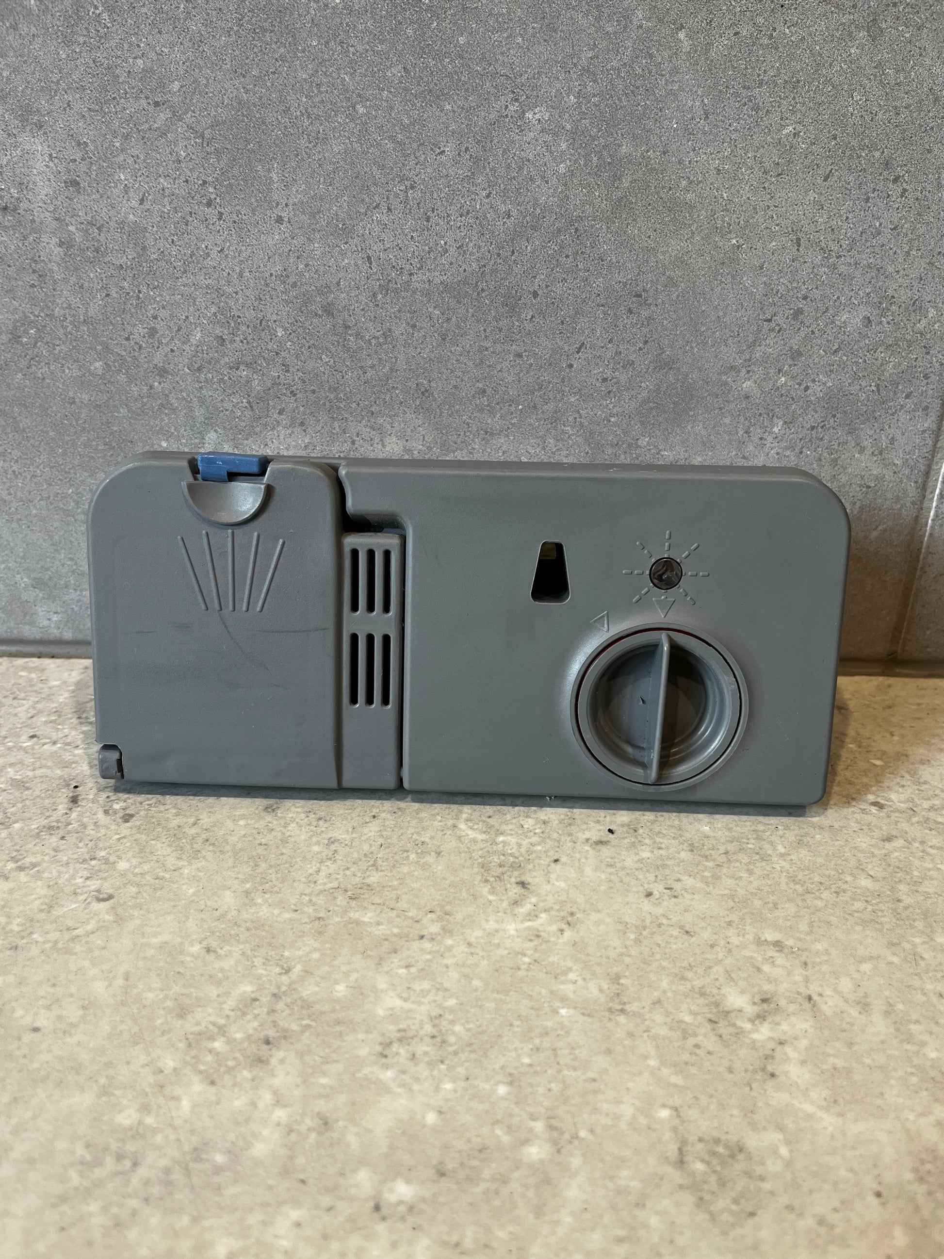 Front view of dishwasher detergent dispenser assembly with control dial