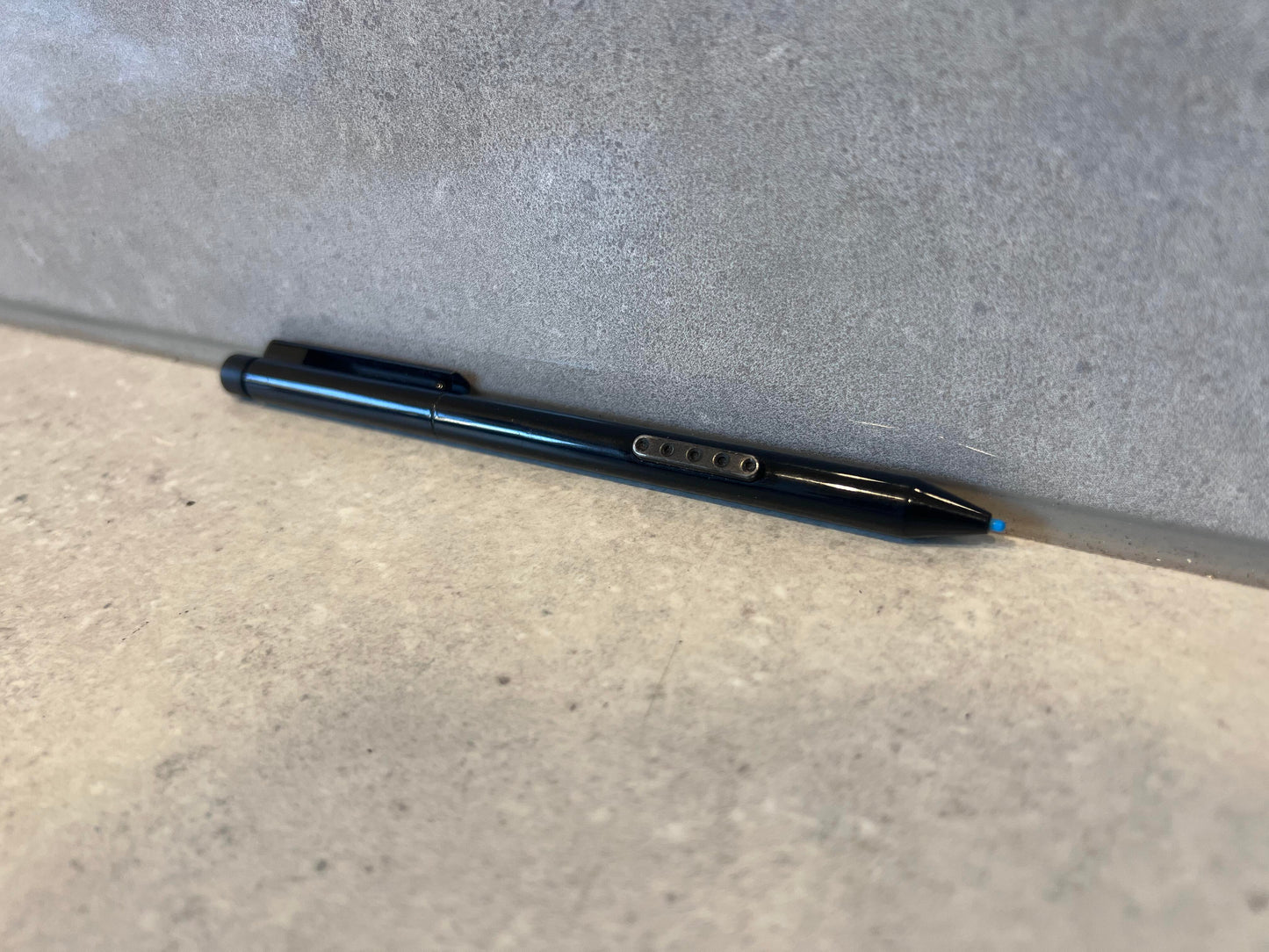 Glossy black retractable ballpoint pen placed on a tabletop