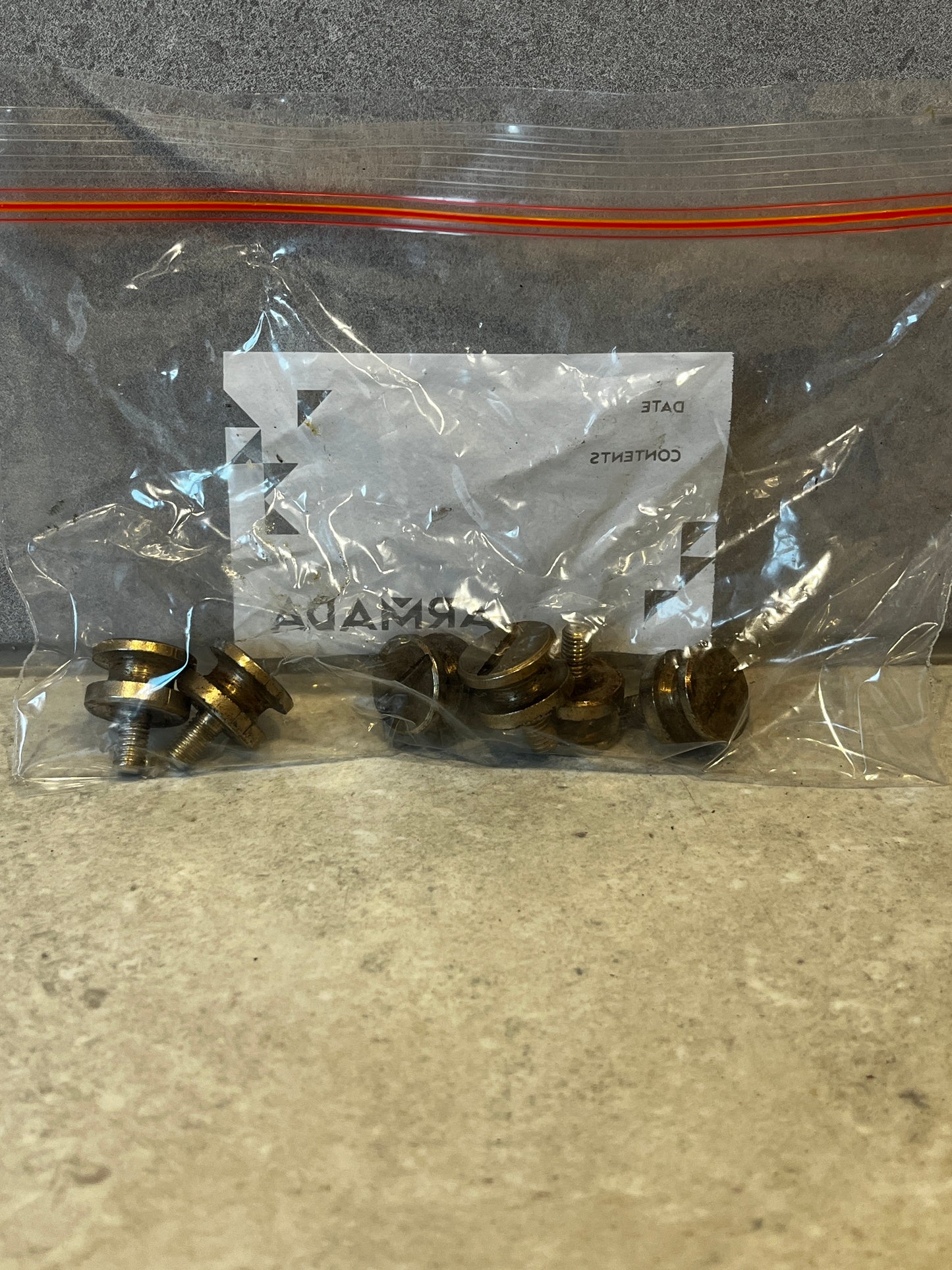 Set of brass thumb screws in a clear resealable plastic bag