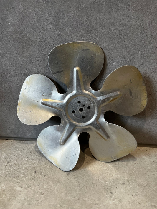 Metal five-blade fan replacement part on gray background