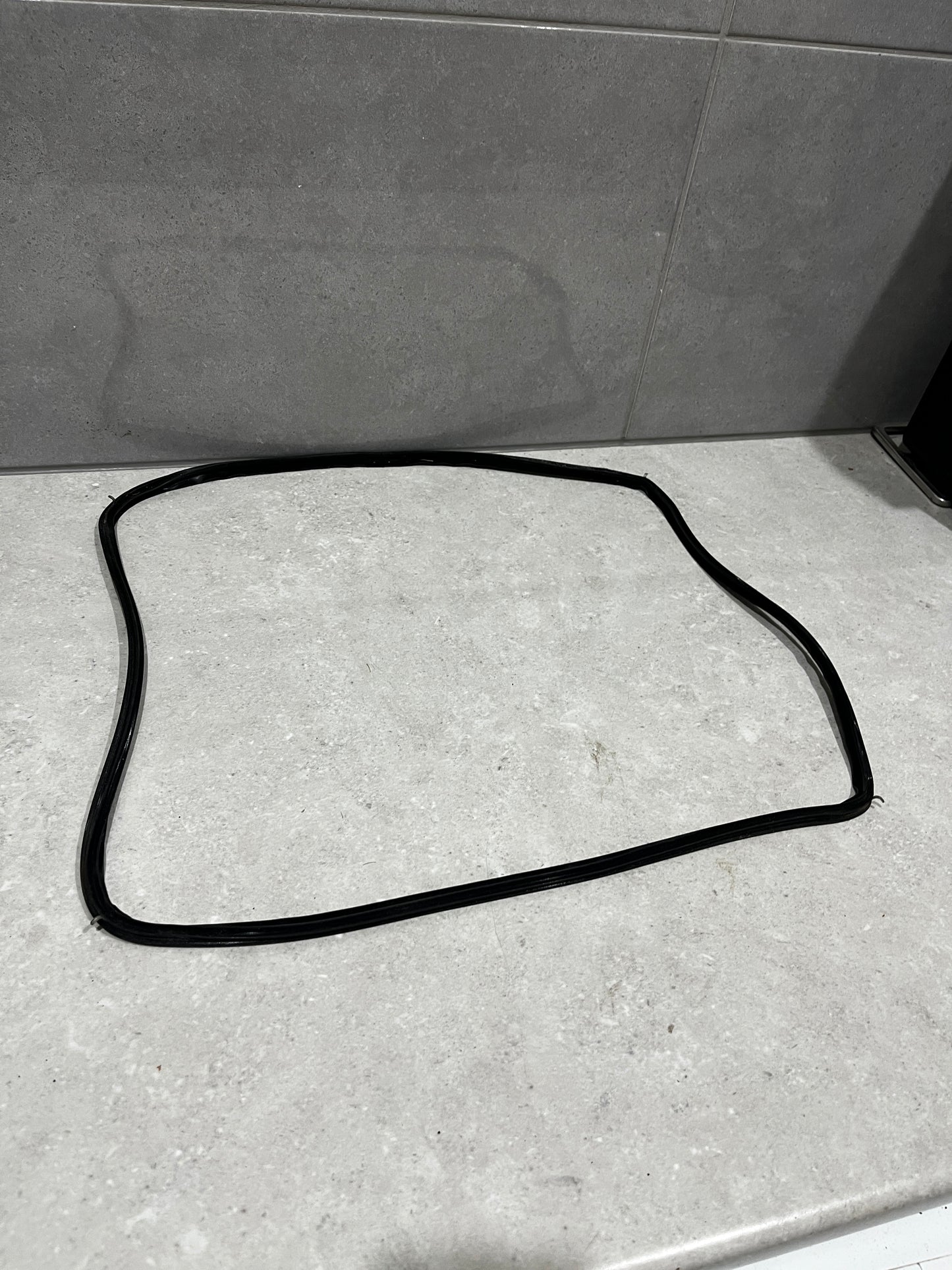 Black rubber window seal gasket laid out on a light countertop