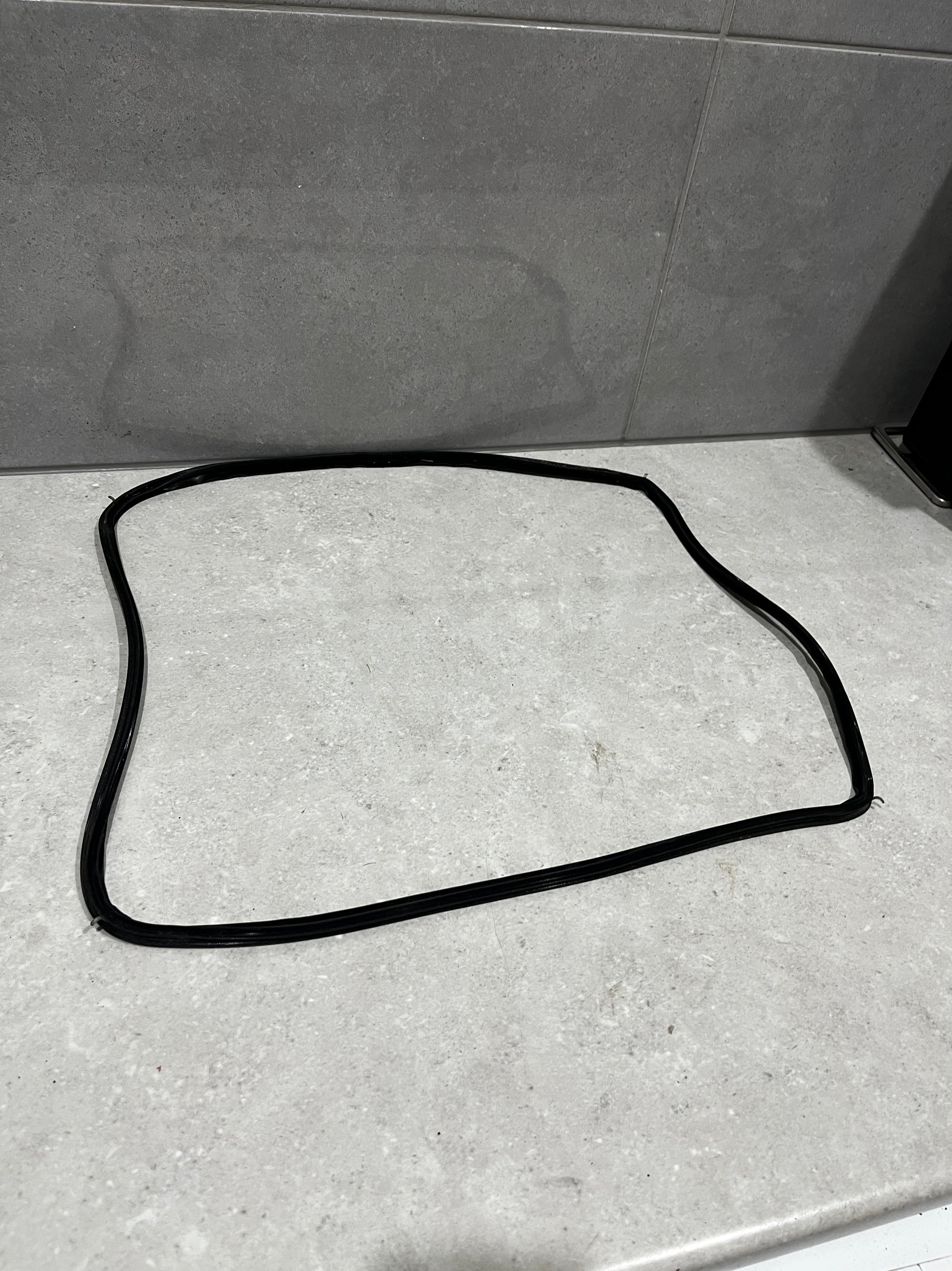 Black rubber window seal gasket laid out on a light countertop