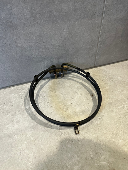 Electric oven heating element coiled and placed on light grey tile surface