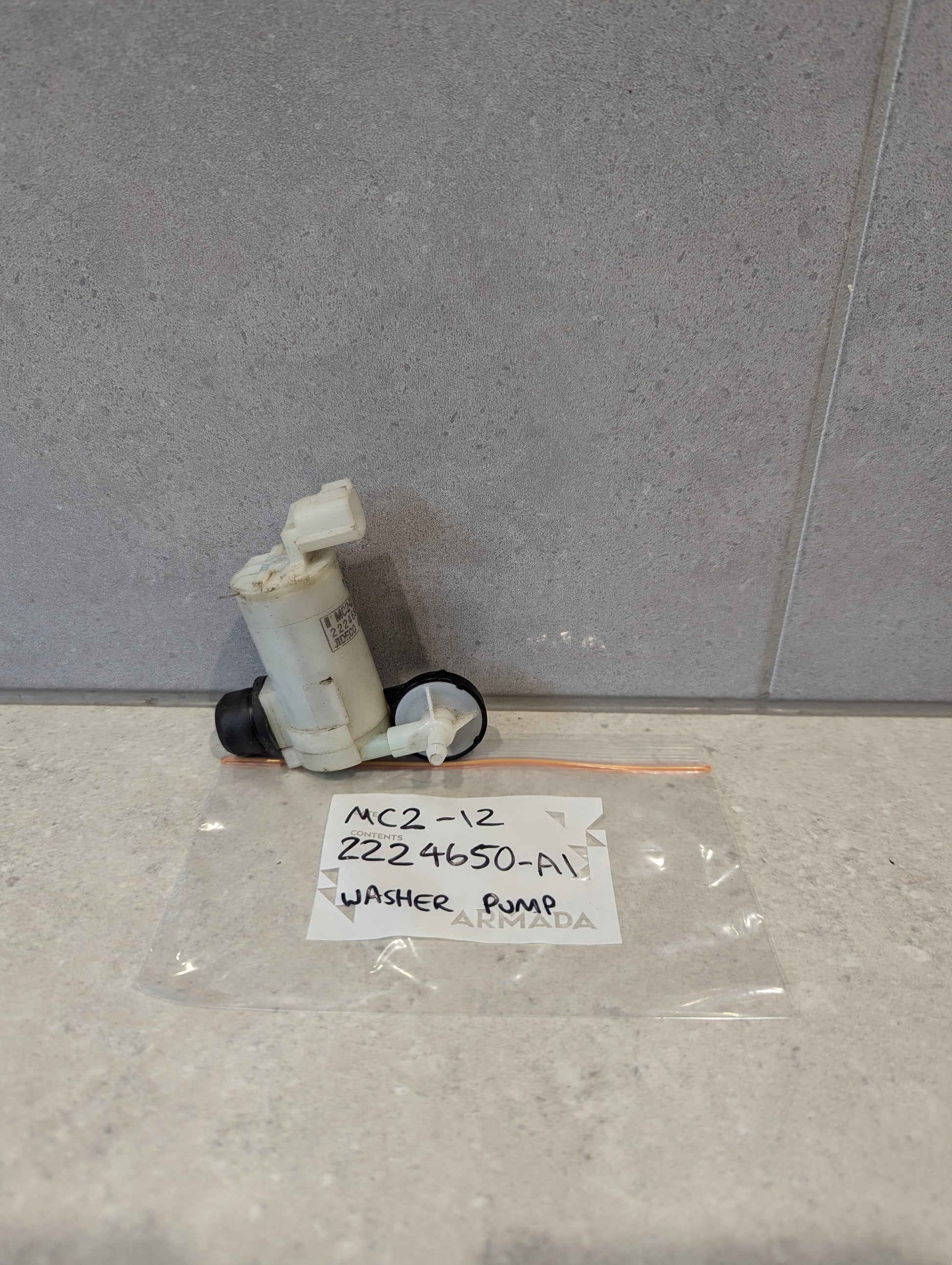 Automotive washer pump 224650-A1 shown with labeled plastic bag