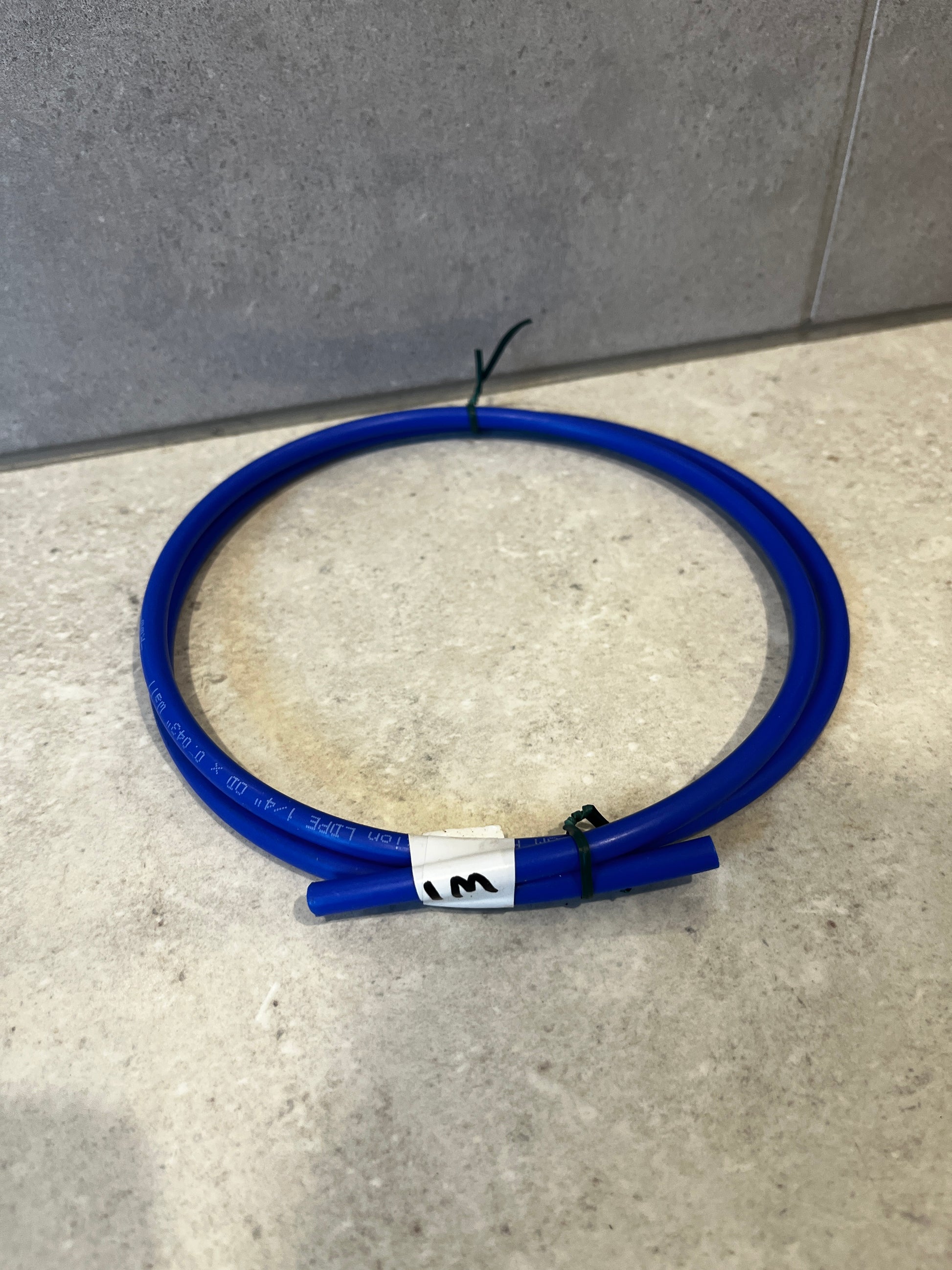 Blue polyurethane tubing coil on stone surface