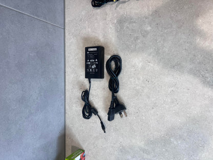 SAN HUA 12V 4A AC adapter with power cable on light surface