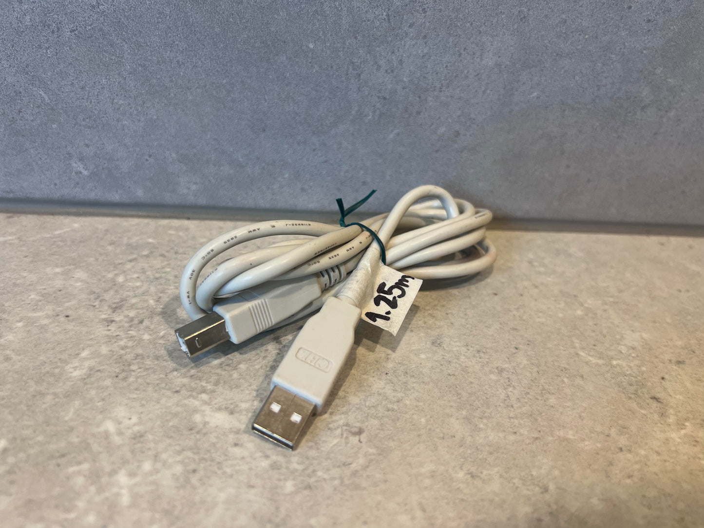 Coiled USB A to USB B cable with 1.25m label