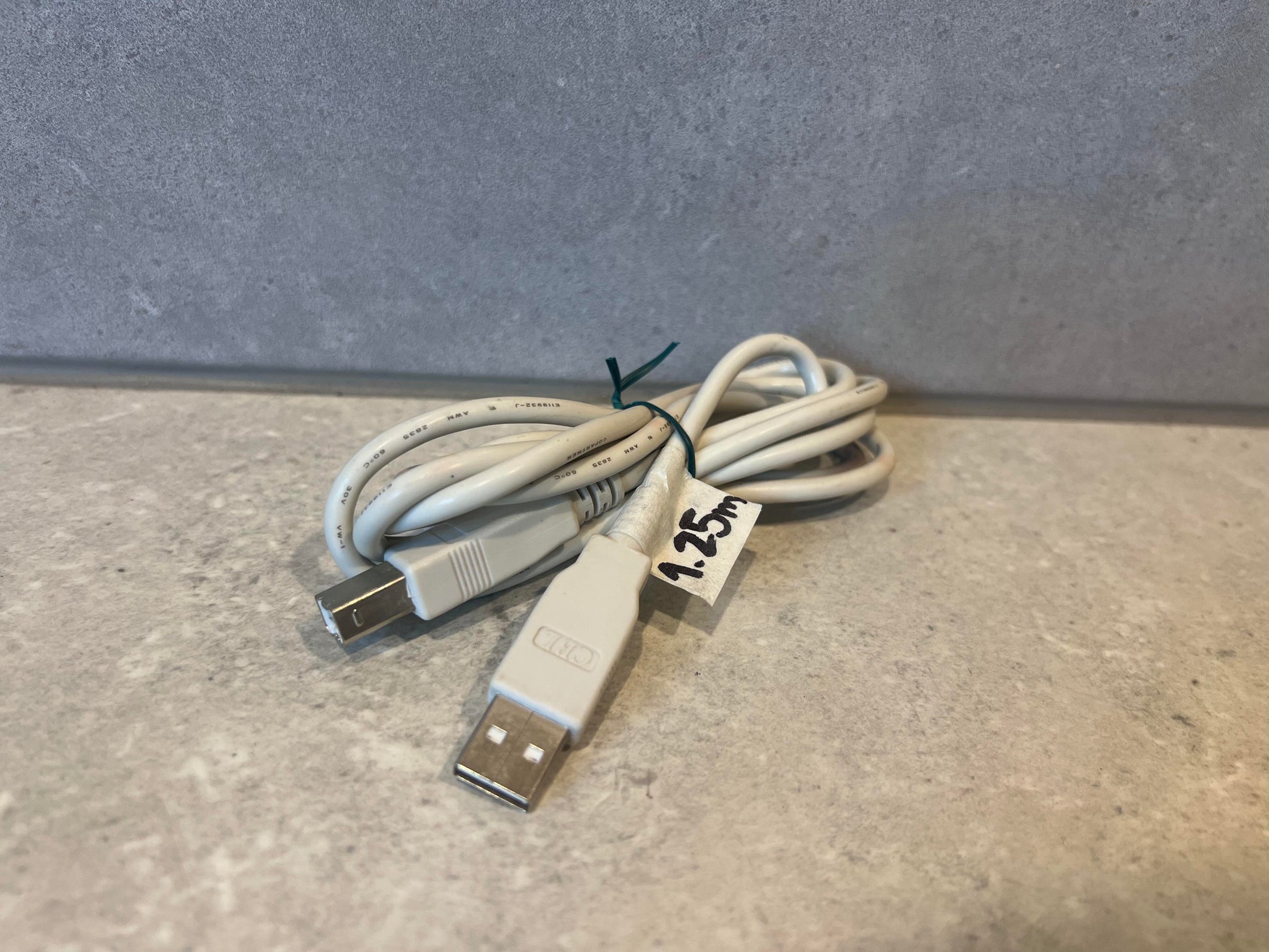 Coiled USB A to USB B cable with 1.25m label