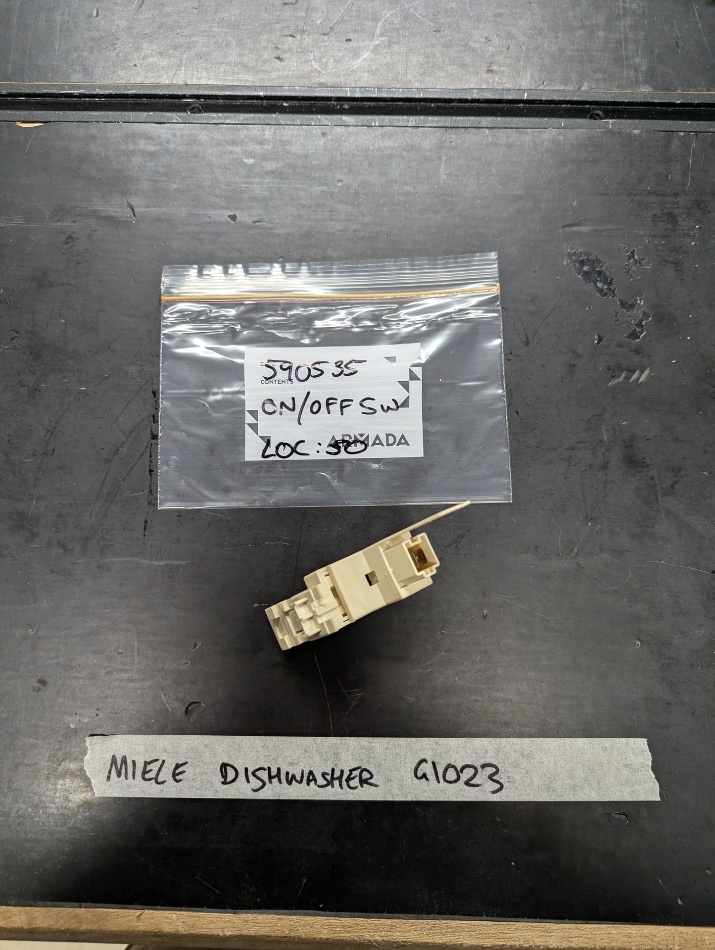 Miele G1023 dishwasher on off switch replacement part on black surface