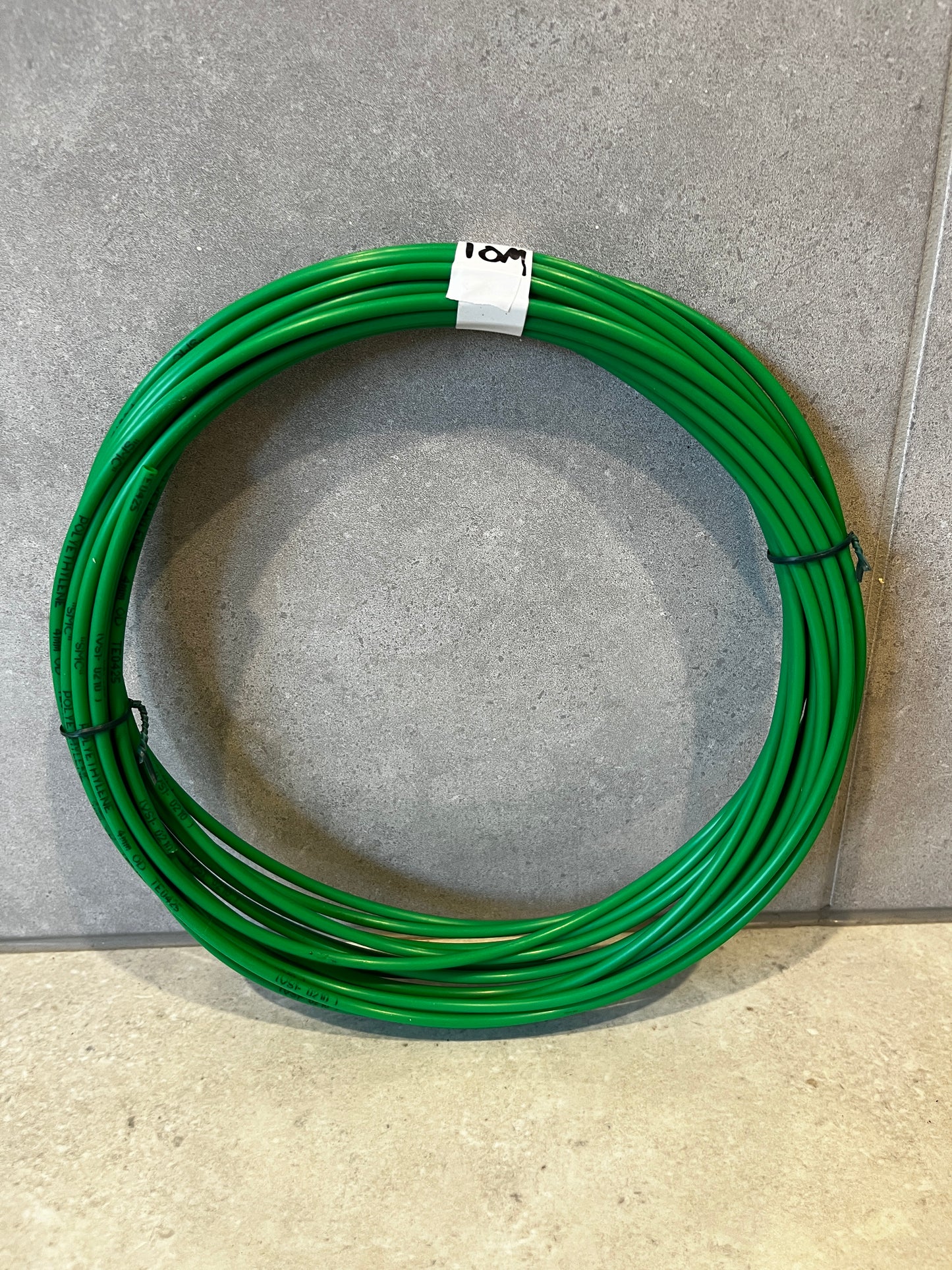 Green polyethylene wire coil neatly coiled with white label