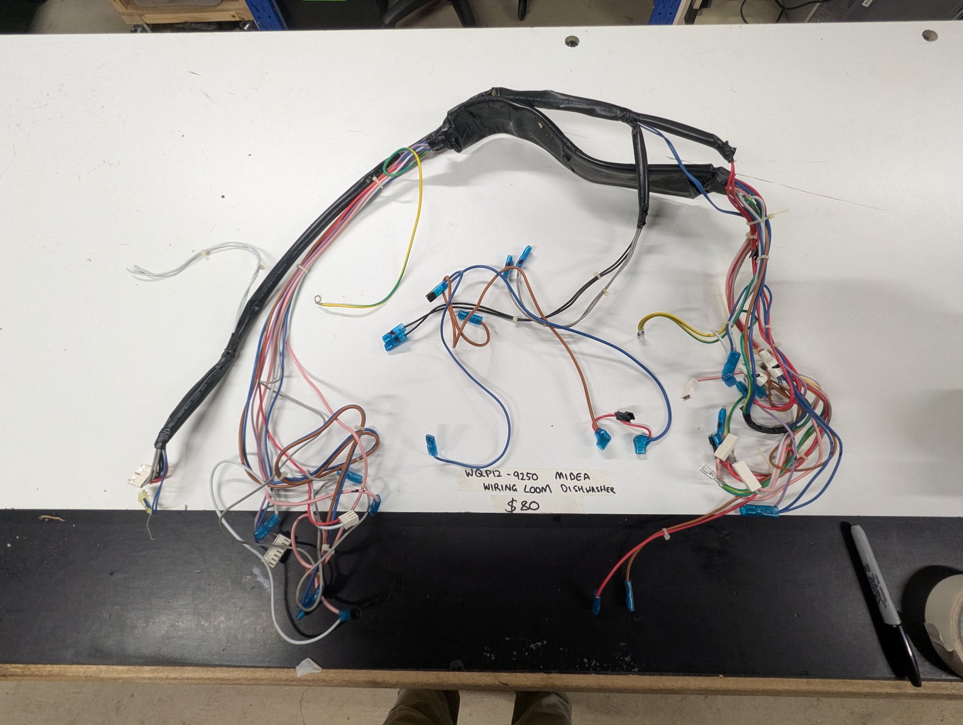 Midea dishwasher wiring loom harness on white table with color-coded wires and connectors