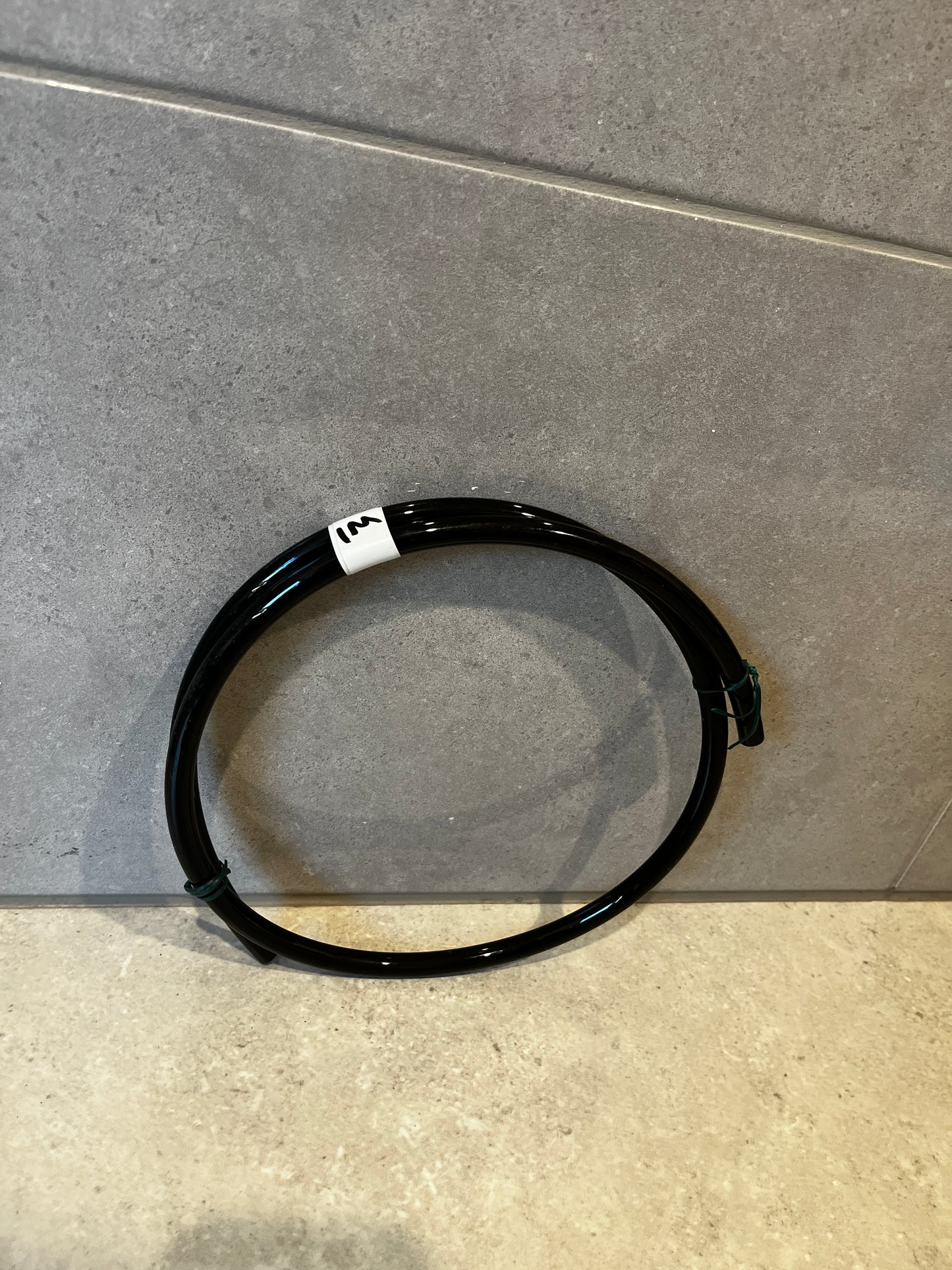Black polyurethane tubing coiled on floor