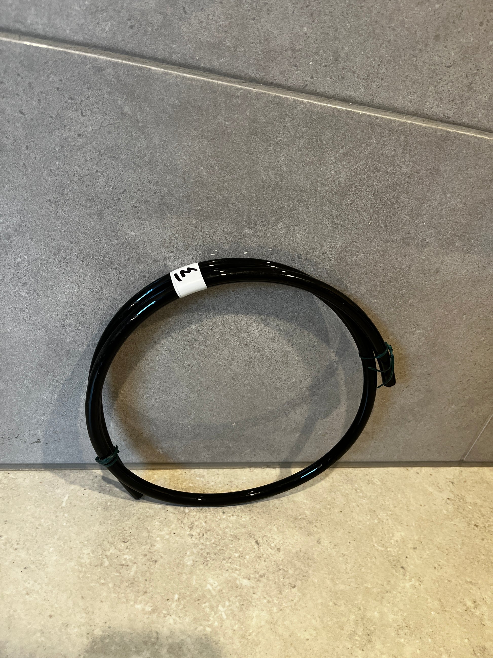Black polyurethane tubing coiled on floor