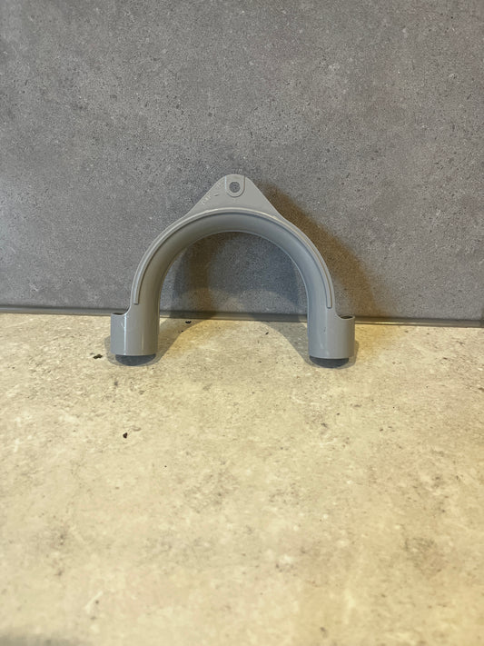 Gray plastic pipe hanger on stone surface
