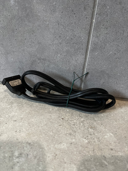 Coiled two-prong black power cord on a stone surface
