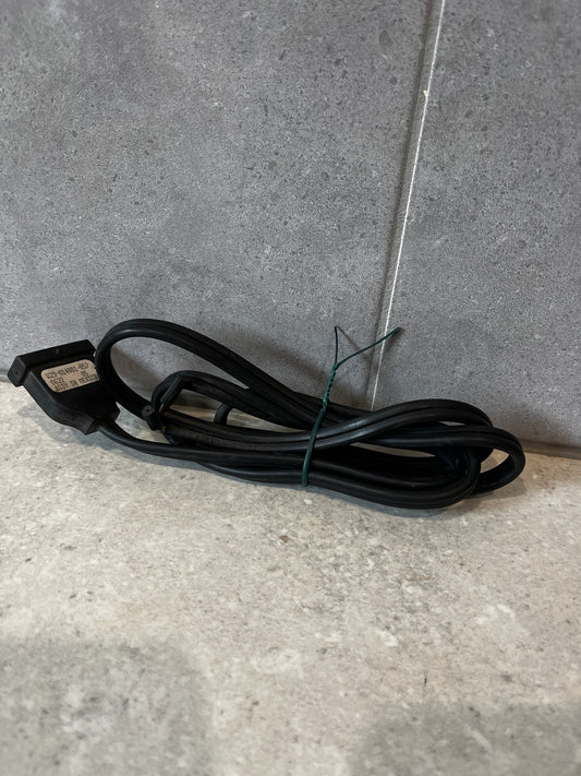 Coiled two-prong black power cord on a stone surface