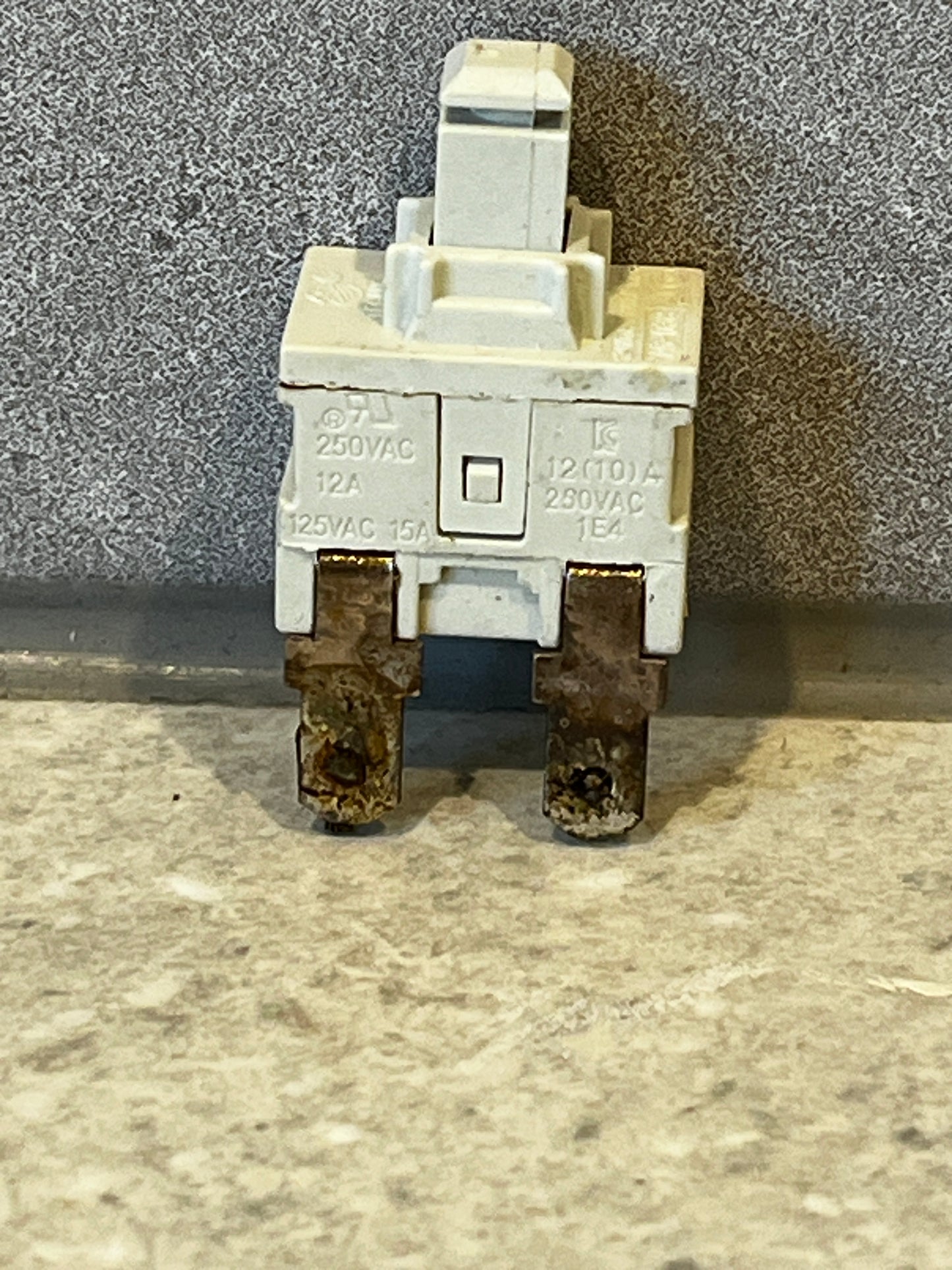 white electrical switch component with metal terminals on countertop