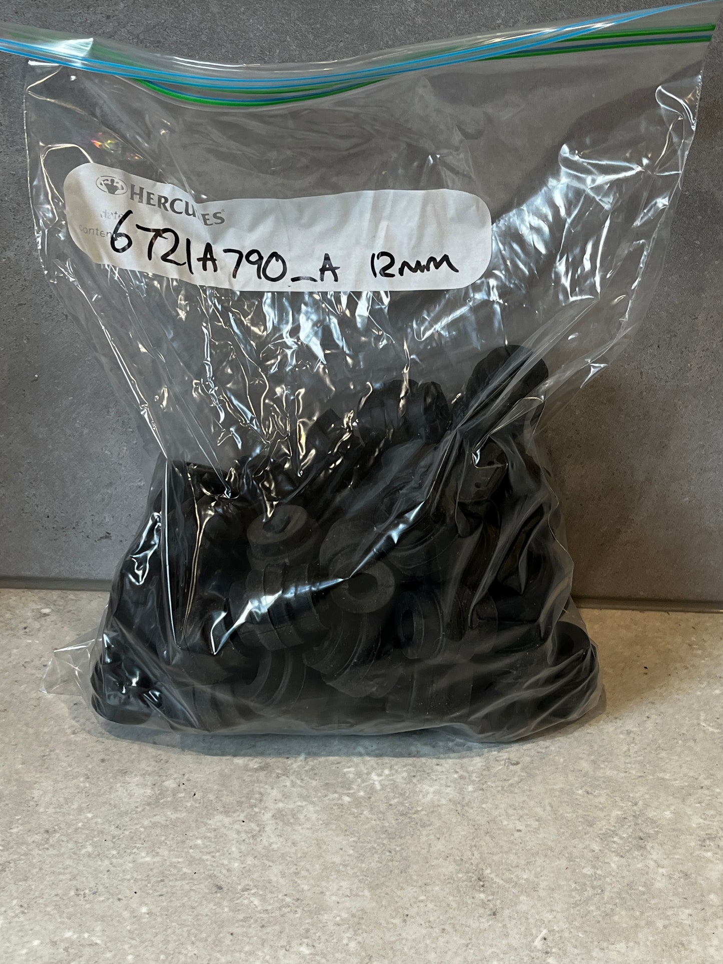 Bag of bulk black rubber grommets labeled 12mm