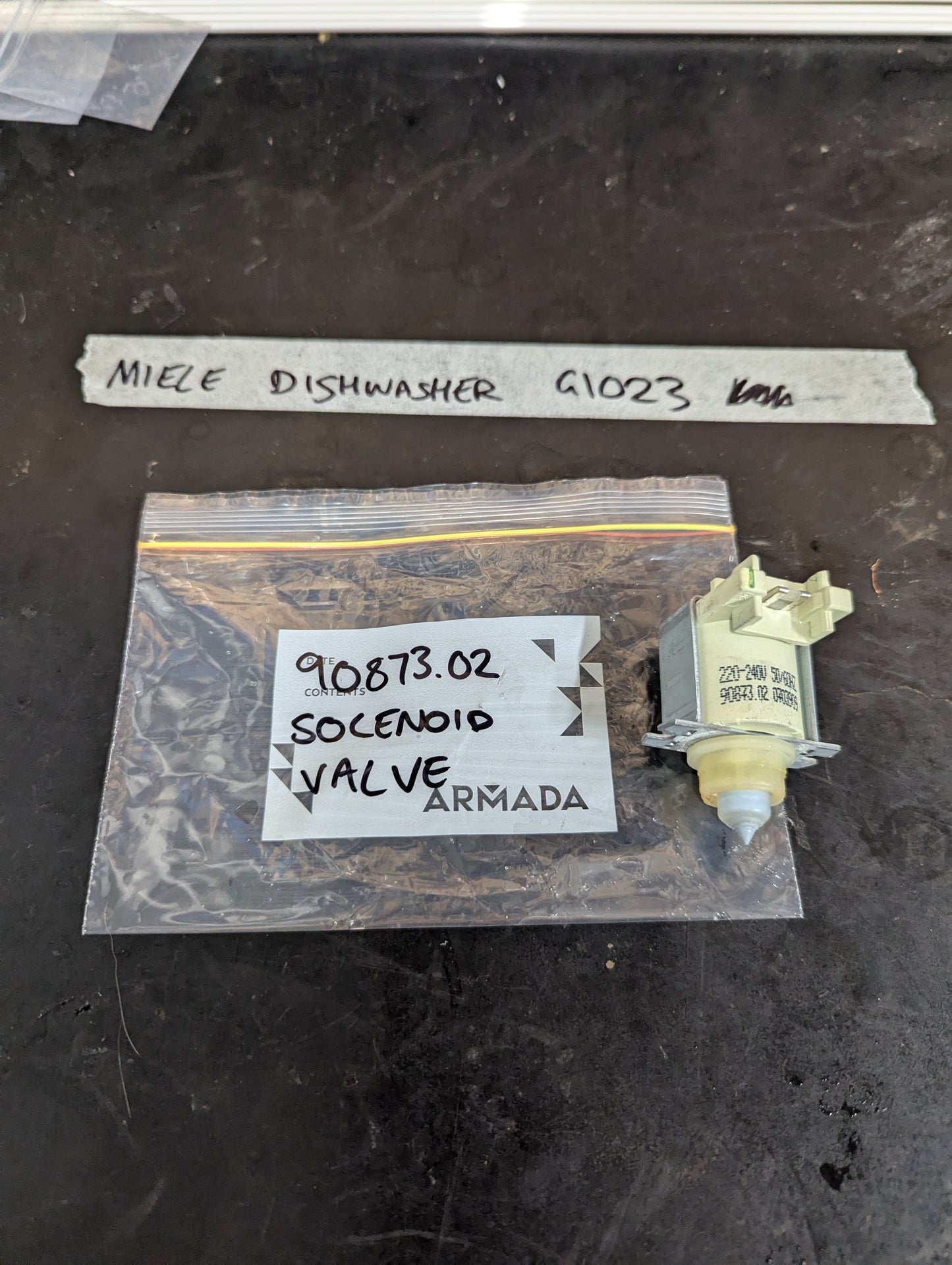 Miele G1023 dishwasher solenoid valve next to labeled bag