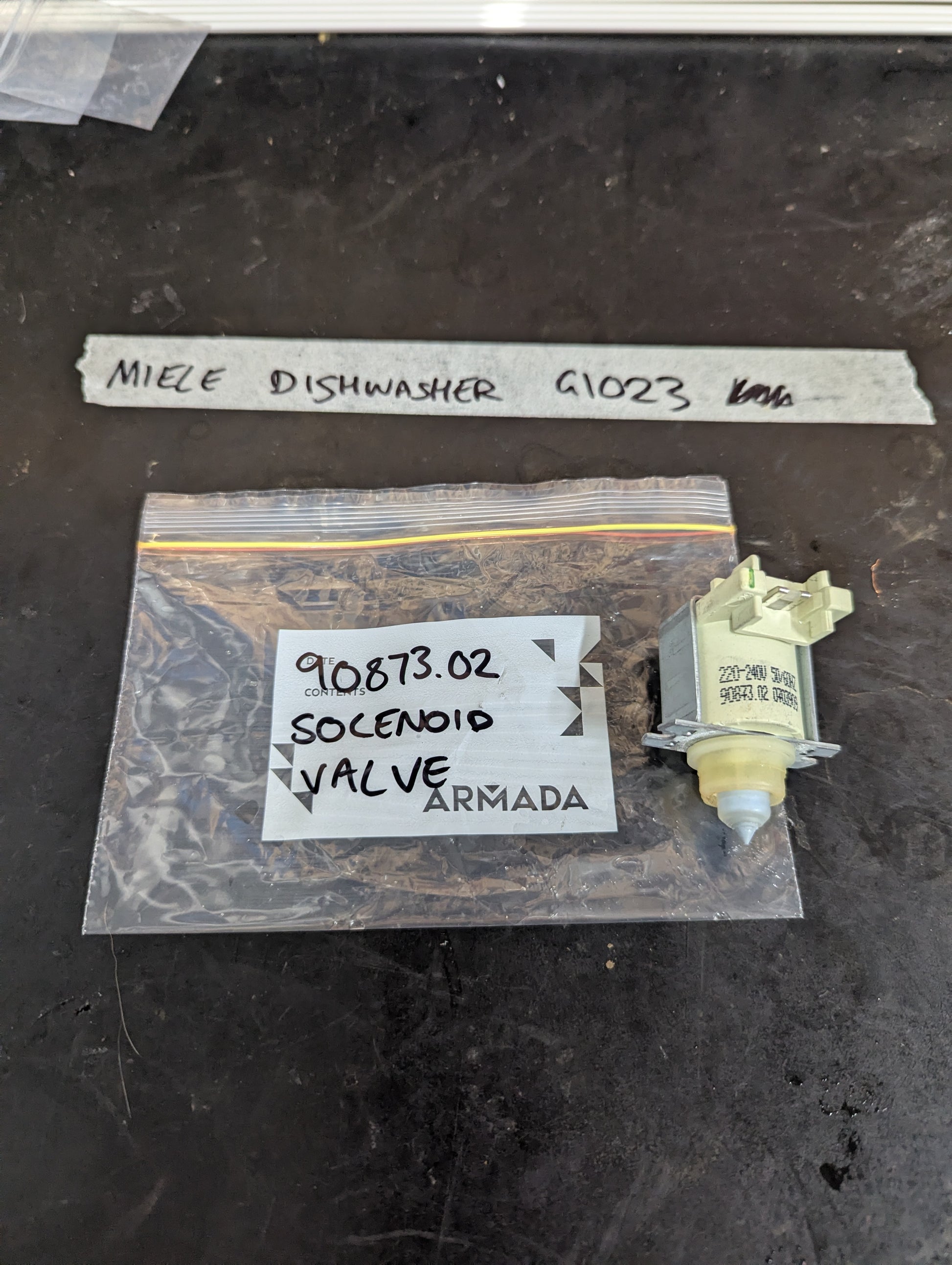 Miele G1023 dishwasher solenoid valve next to labeled bag