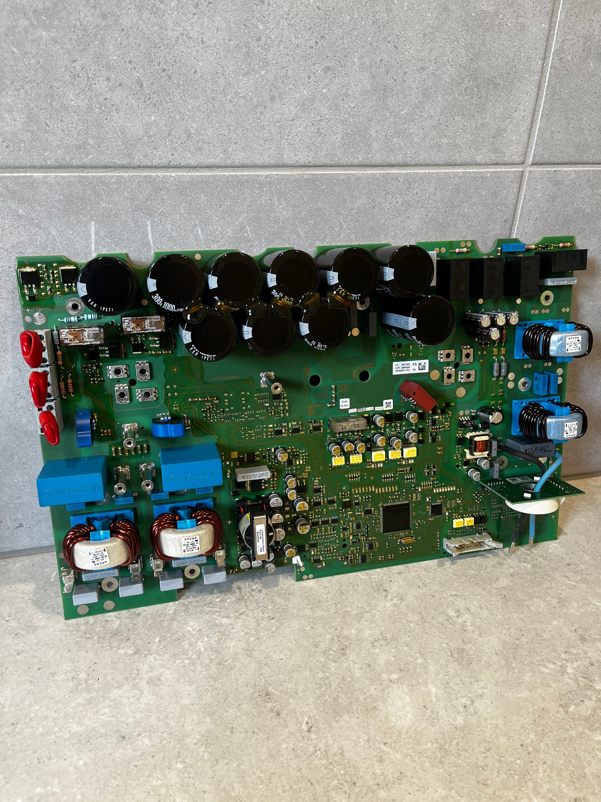 High-performance power control circuit board with capacitors and coils on a tiled surface