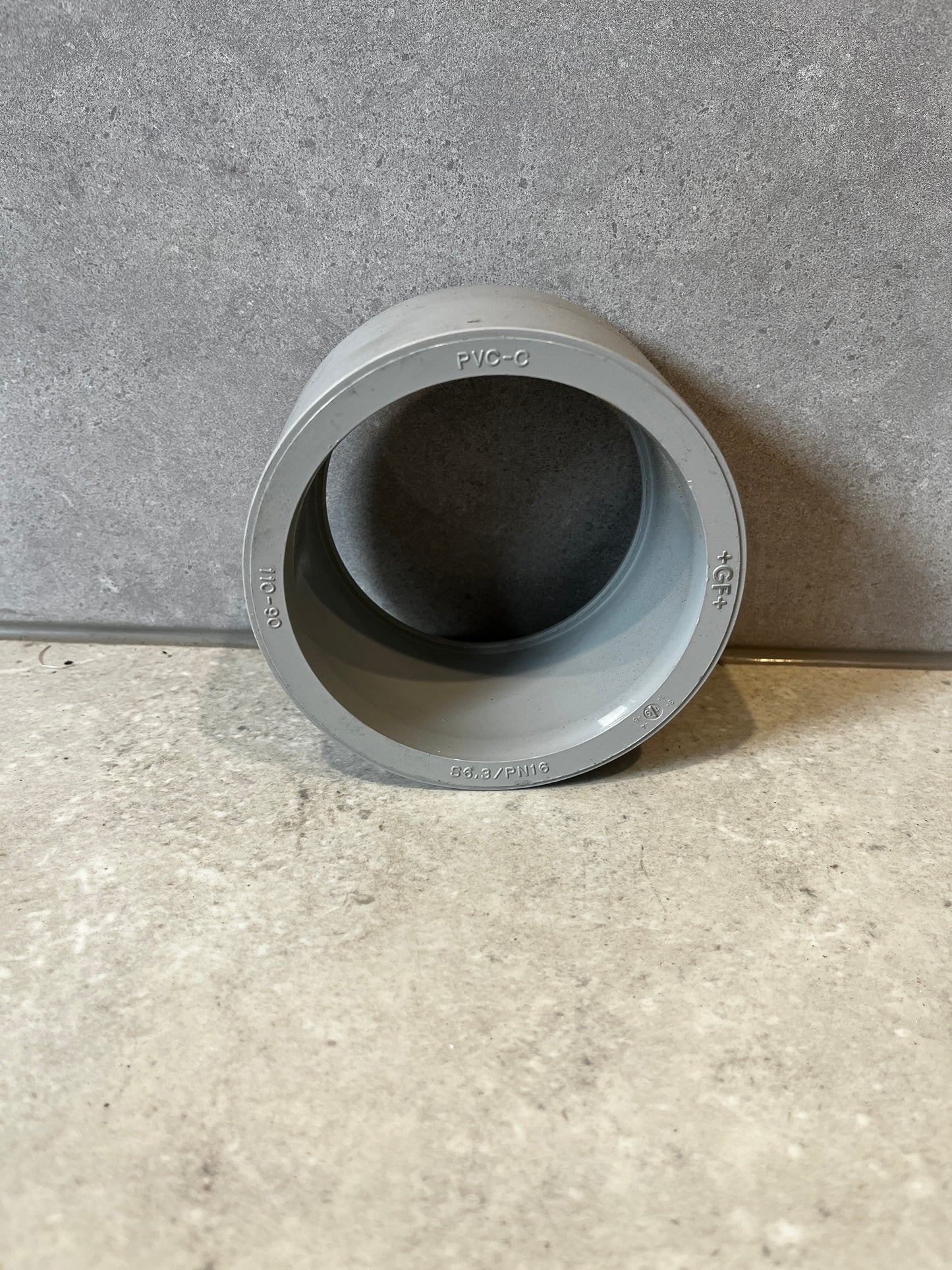 Gray PVC pipe coupling socket adapter front view