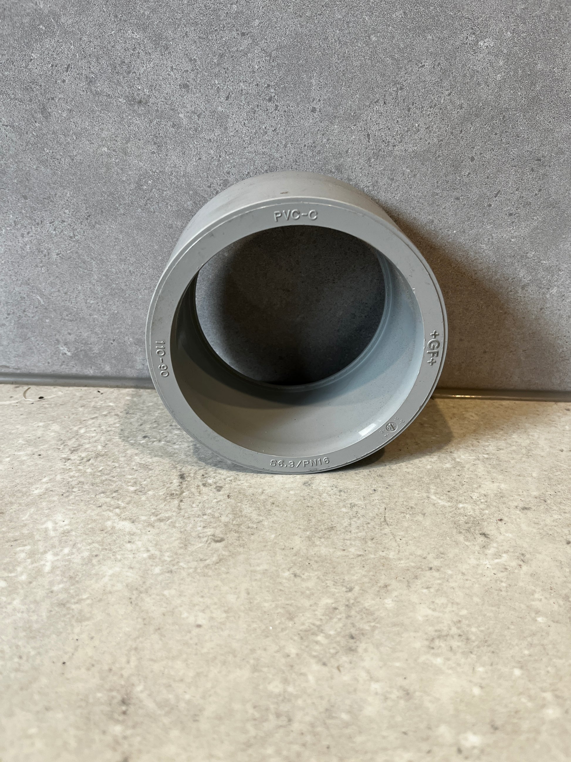 Gray PVC pipe coupling socket adapter front view