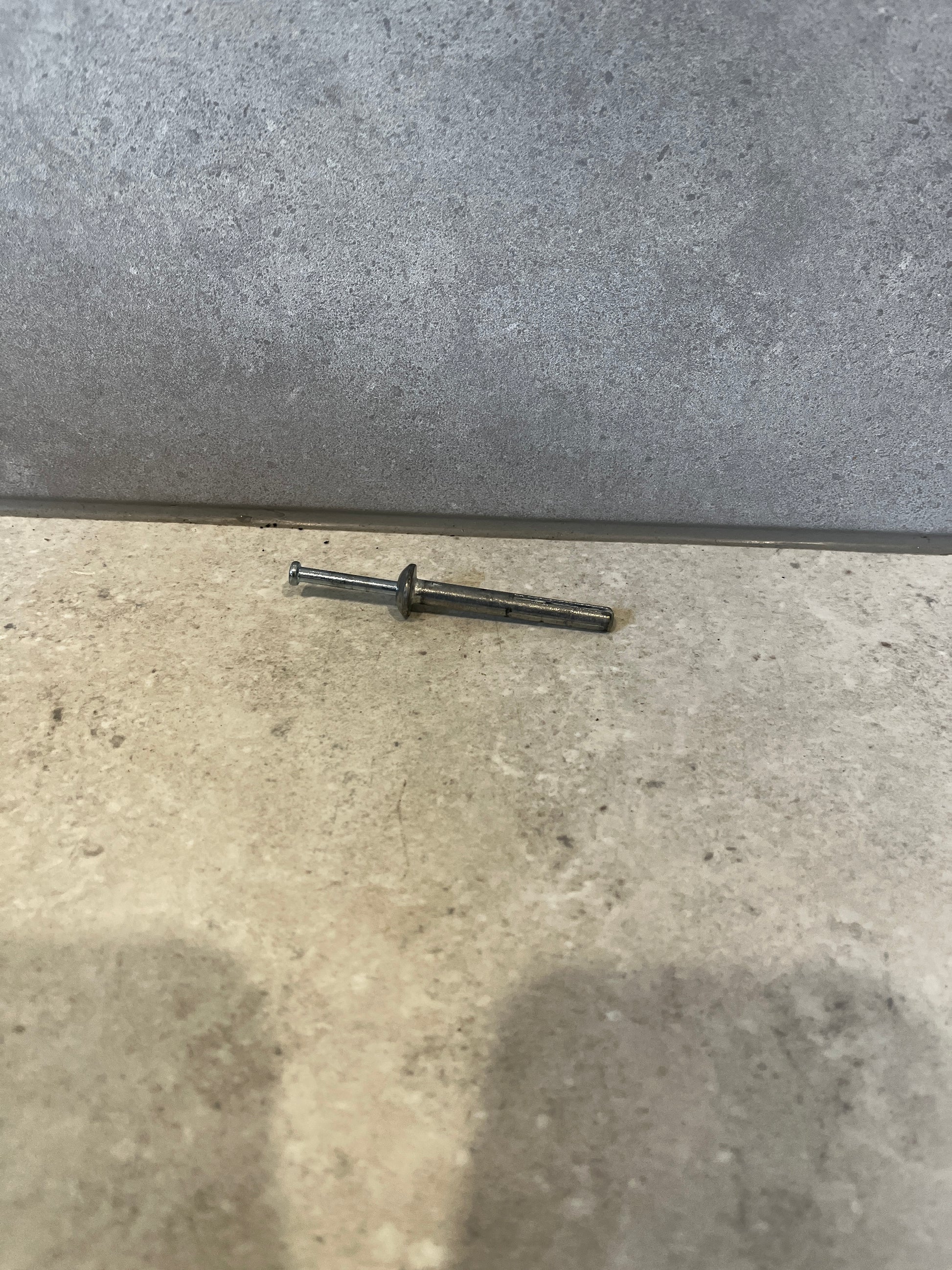 Single ICCONS metal drive anchor on tile surface
