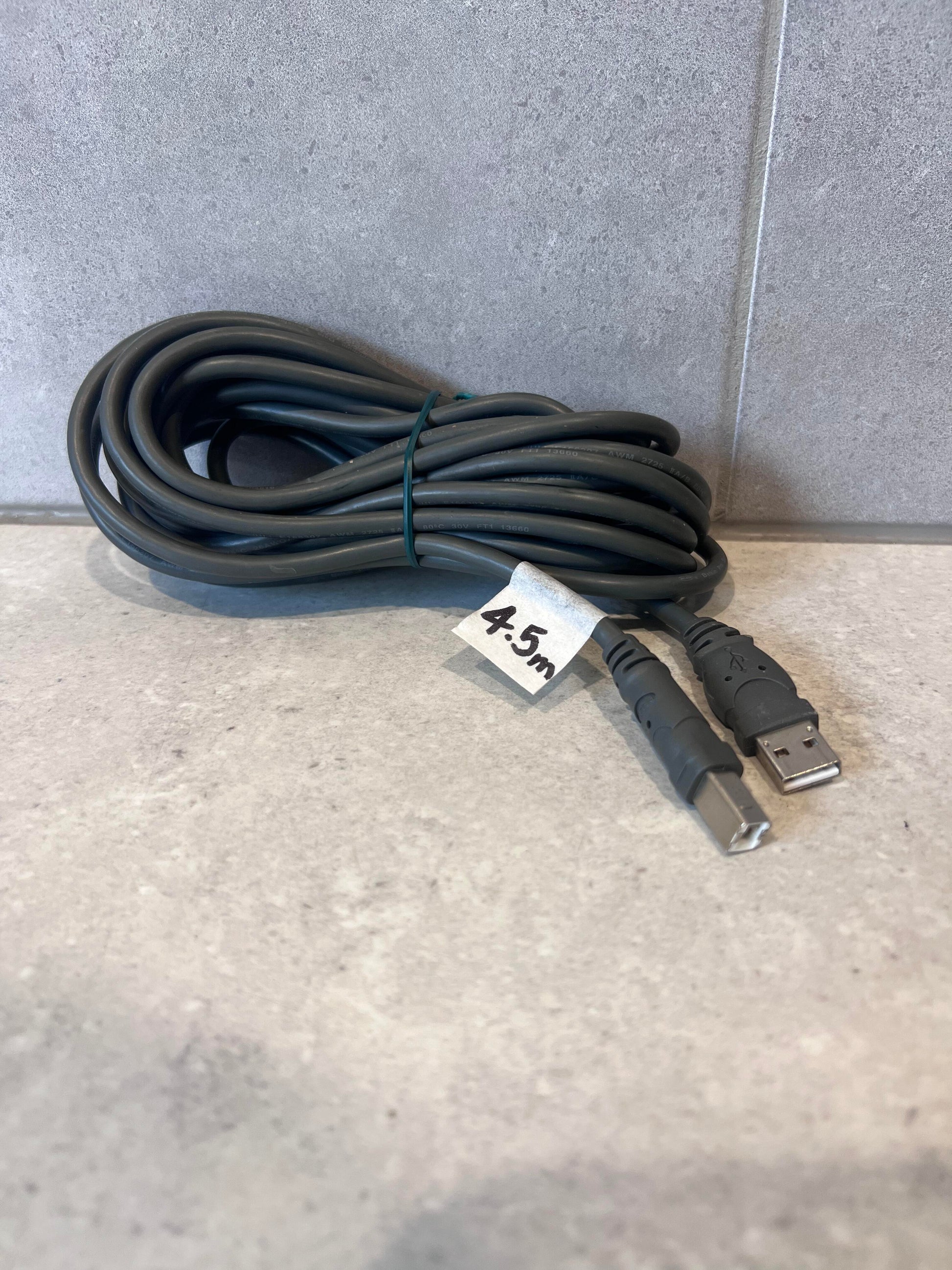Coiled 4.5 meter USB A to USB B cable on a gray surface