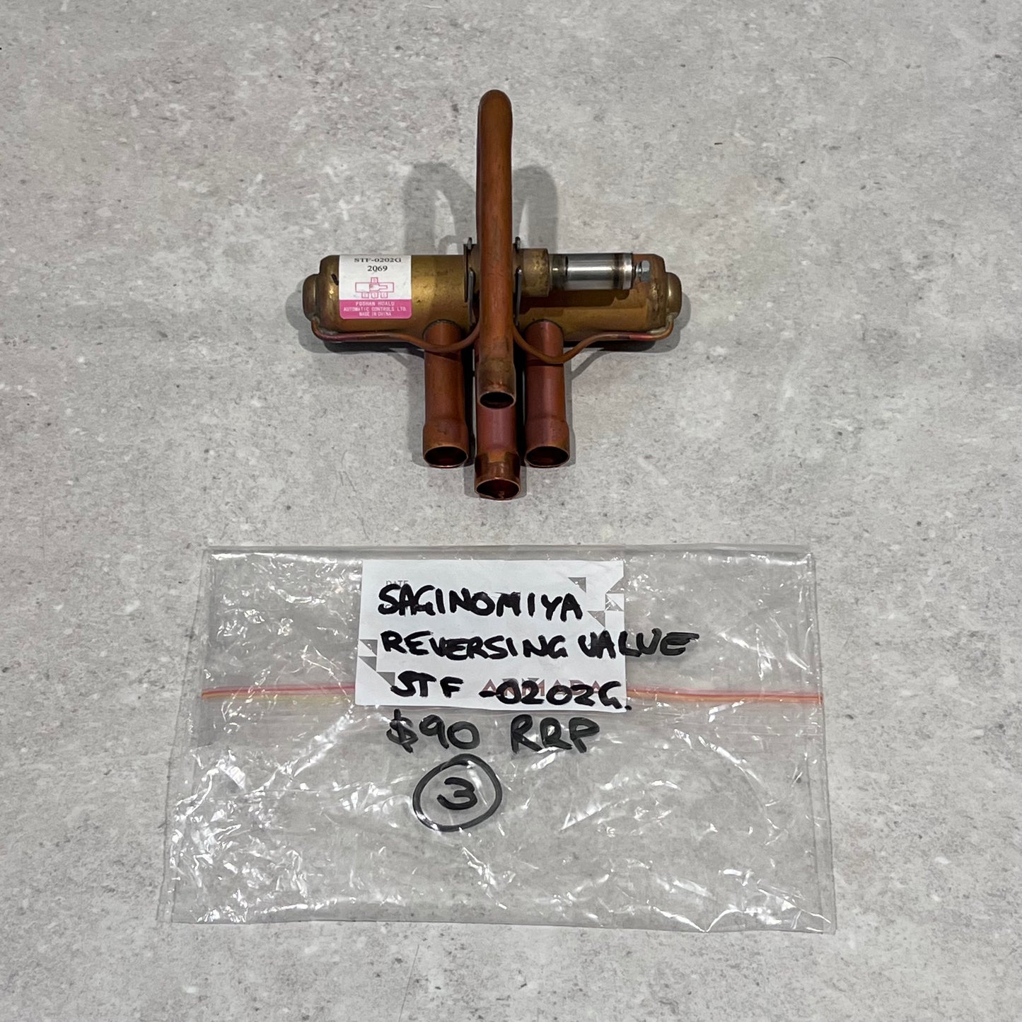 Saginomiya STF40202G reversing valve with labeled bag on gray surface