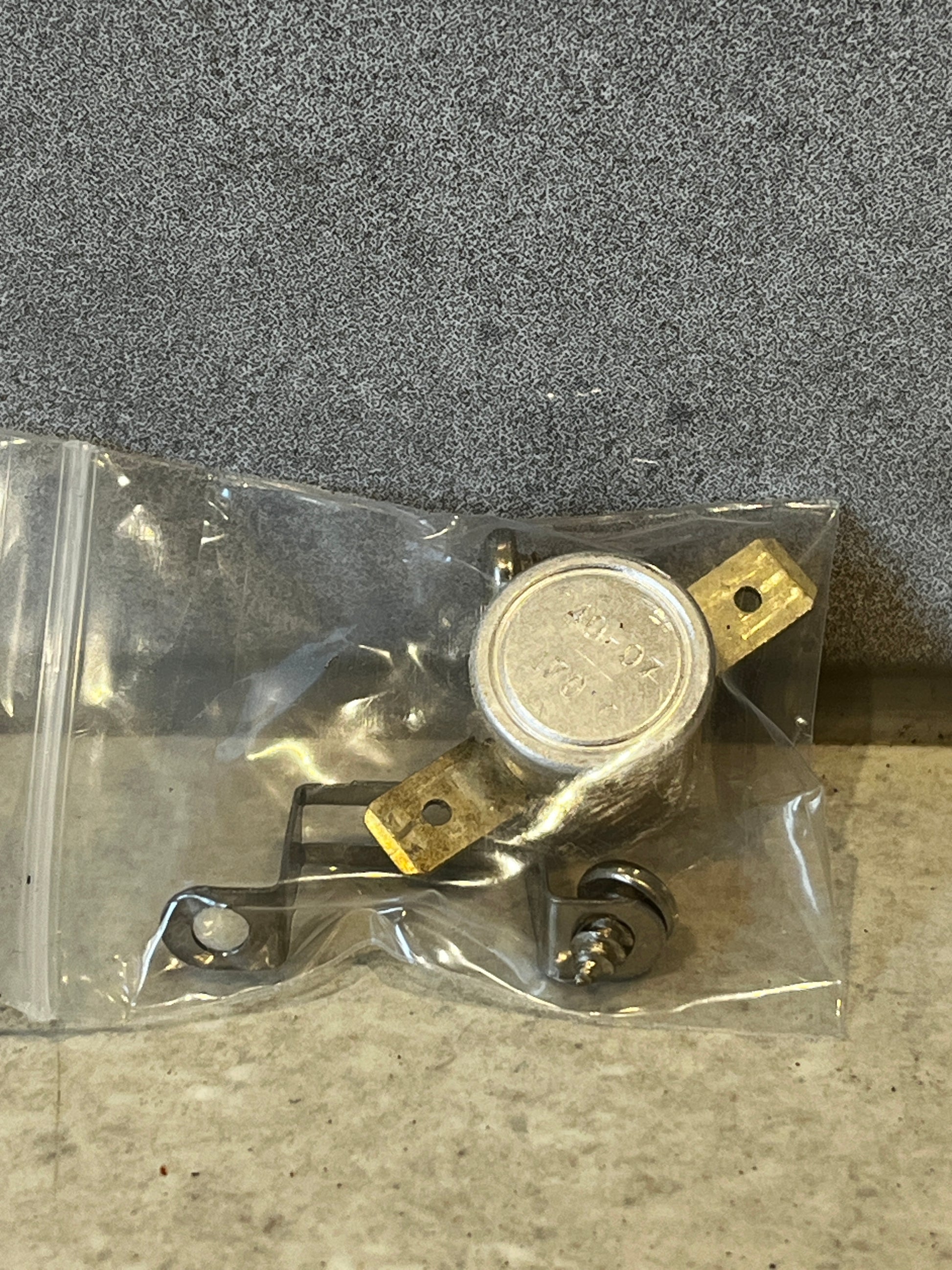 Metal thermal switch with brass terminals and mounting bracket sealed in plastic bag