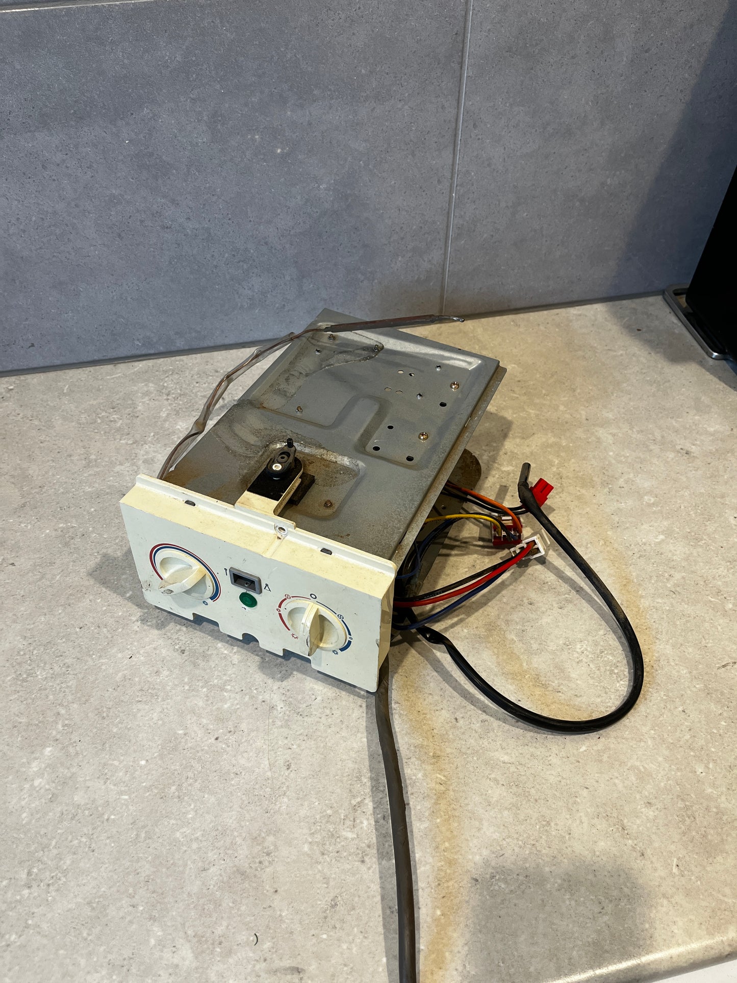 Thermostat control panel assembly with dual knobs and wiring harness on countertop