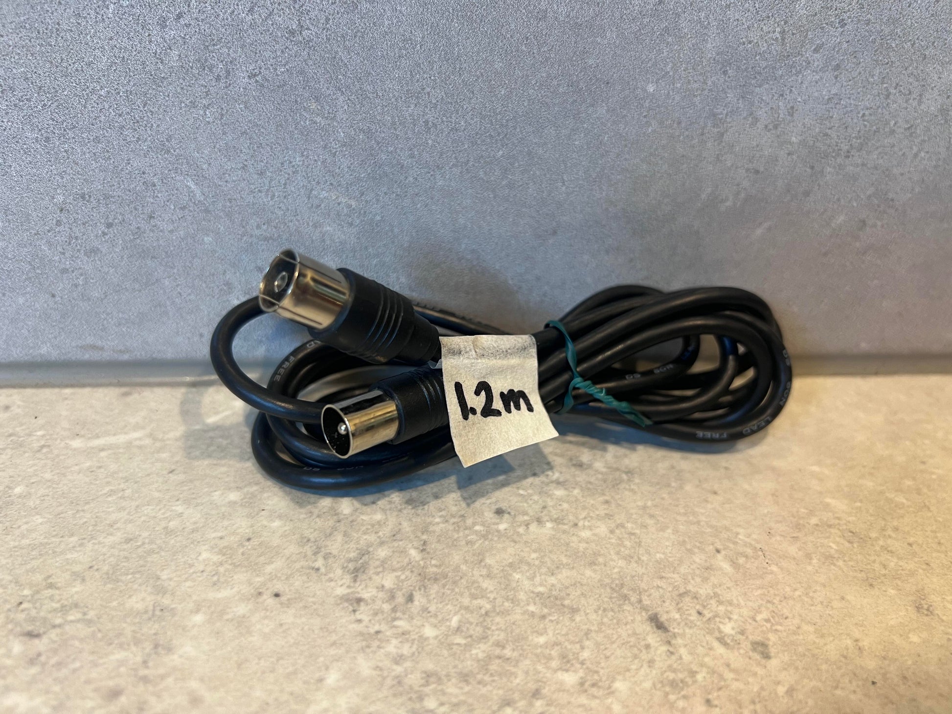 Coiled black DIN male to female cable with 1.2m label on a light background