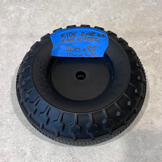 Black plastic replacement wheel for kids ride-on car, 200x85 mm size, with center hole and treaded pattern