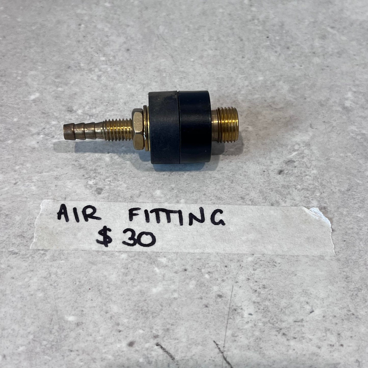 Air fitting for CUT50 plasma cutter with brass and black finish on gray surface