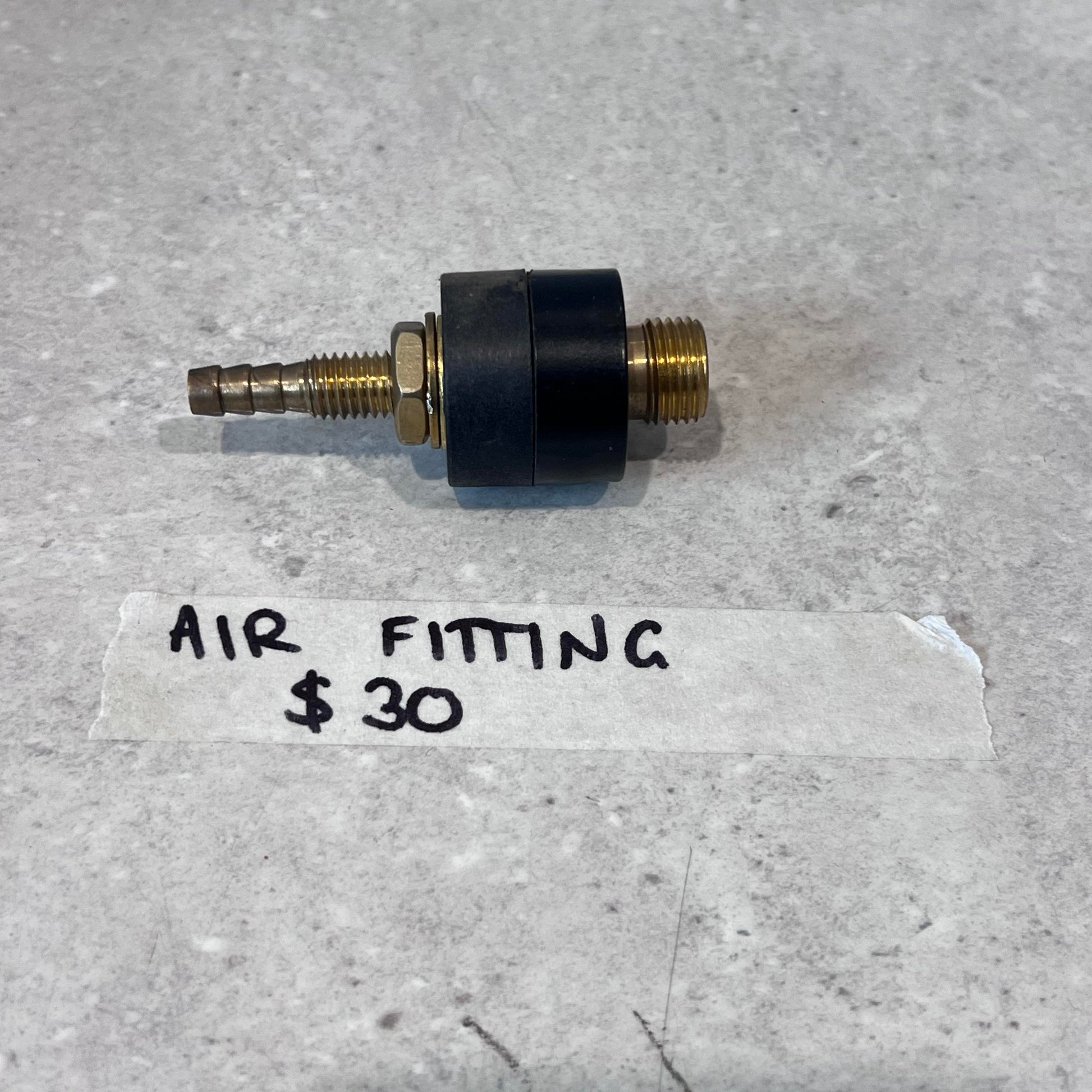 Air fitting for CUT50 plasma cutter with brass and black finish on gray surface