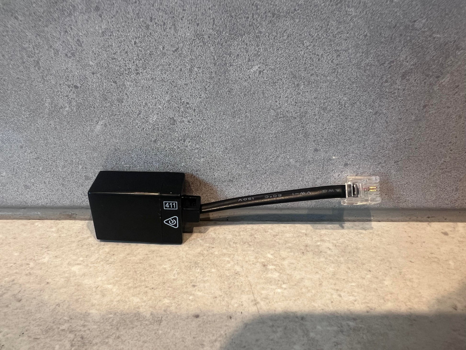 Black RJ11 telephone line tester adapter with attached cable and connector