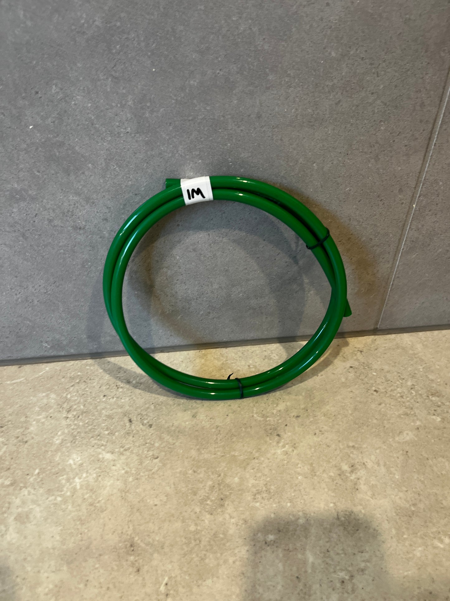 Coiled green pneumatic tubing on floor